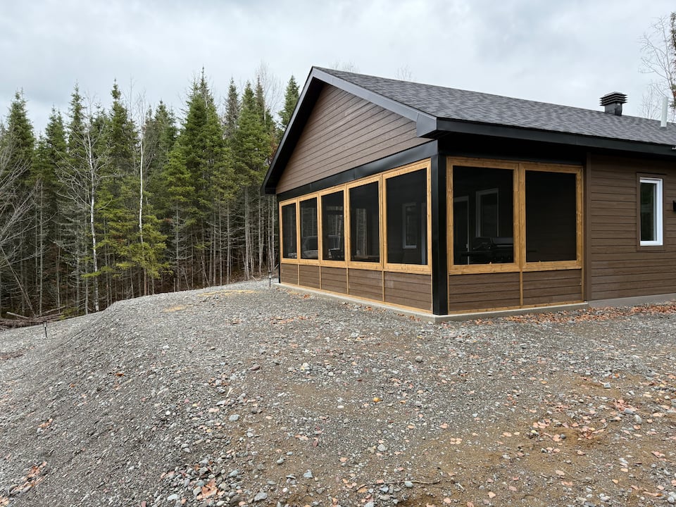 Shack à Boucane and its screened porch beside the forest